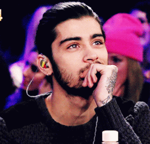 A Man With A Beard Wearing Ear Buds And A Tattoo On His Wrist GIF