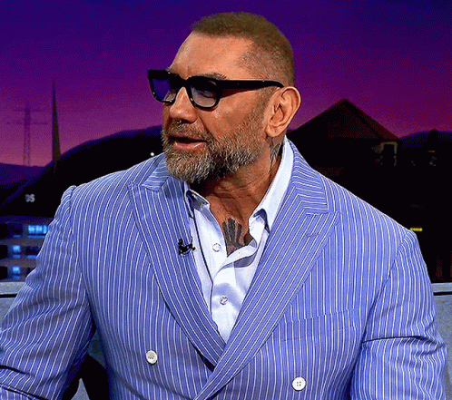 A Man With A Beard Wearing Glasses And A Blue Striped Jacket GIF