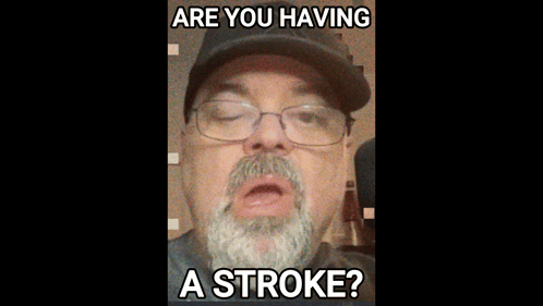 A Man With A Beard Wearing Glasses And A Hat Says Are You Having A Stroke GIF