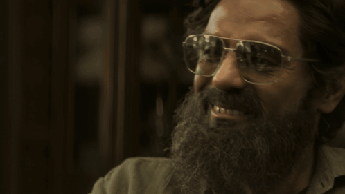 A Man With A Beard Wearing Glasses And Smiling GIF