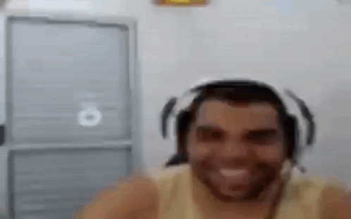 A Man With A Beard Wearing Headphones And A Headset Is Smiling . GIF