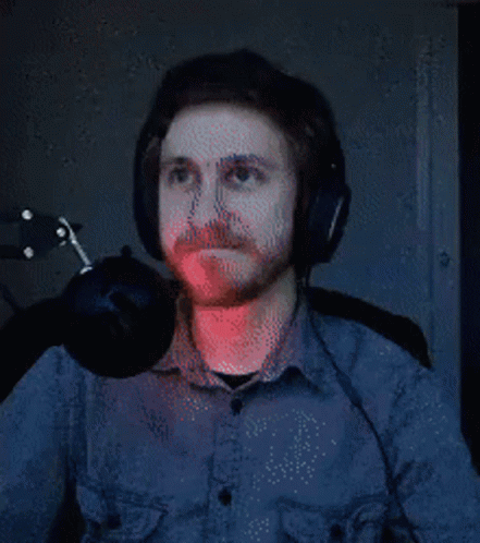 A Man With A Beard Wearing Headphones And A Microphone . GIF