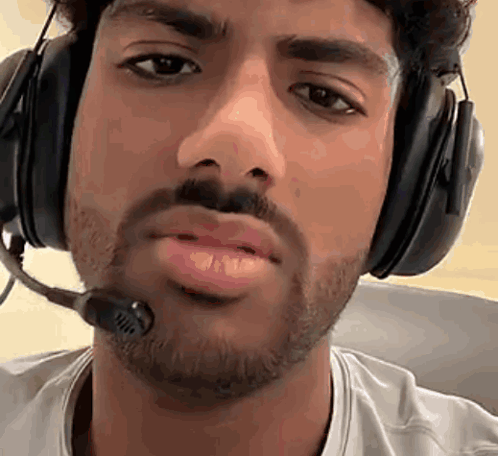 A Man With A Beard Wearing Headphones And A Microphone Around His Neck . GIF