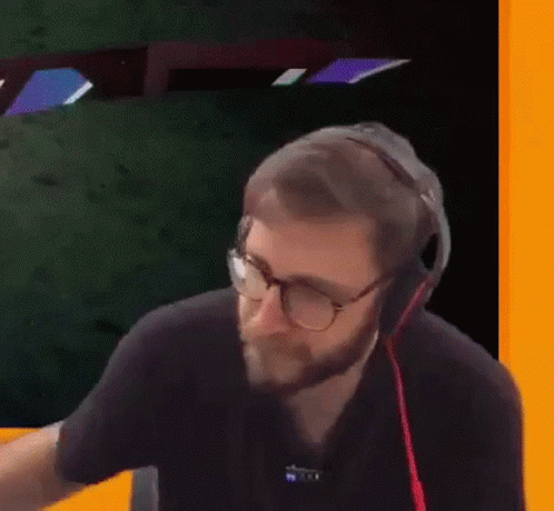A Man With A Beard Wearing Headphones And Glasses Is Holding A Plastic Bag . GIF