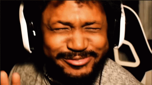 A Man With A Beard Wearing Headphones Is Making A Funny Face GIF