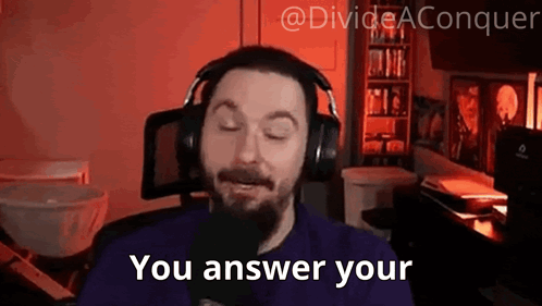A Man With A Beard Wearing Headphones Is Talking Into A Microphone And Saying `` You Answer Your '' . GIF