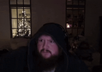 A Man With A Beard Wearing Headphones Looks At The Camera GIF