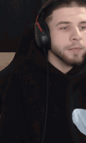 a man with a beard wearing headphones looks to the side
