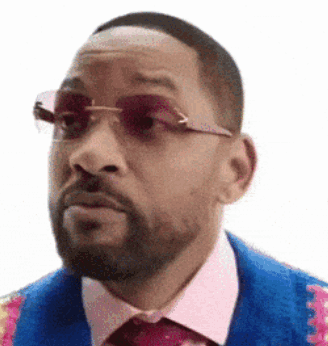 A Man With A Beard Wearing Sunglasses And A Blue Jacket And Tie . GIF