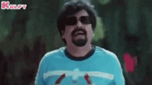 A Man With A Beard Wearing Sunglasses And A Blue Shirt Is Holding A Bottle Of Soda . GIF