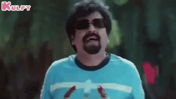A Man With A Beard Wearing Sunglasses And A Blue Shirt Is Holding A Bottle Of Water . GIF