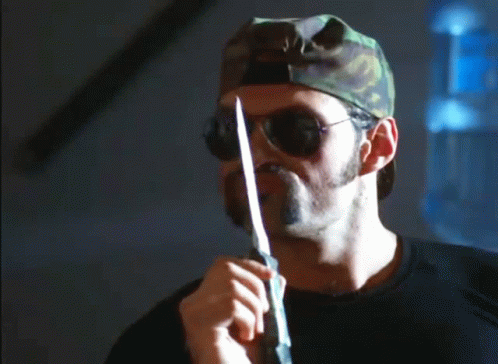 A Man With A Beard Wearing Sunglasses And A Camouflage Hat Says You Never Leave A Man Behind GIF