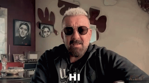 A Man With A Beard Wearing Sunglasses And A Hoodie That Says U Hi GIF