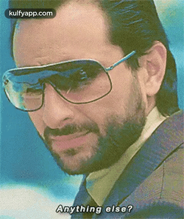 A Man With A Beard Wearing Sunglasses And A Jacket Is Asking Anything Else . GIF