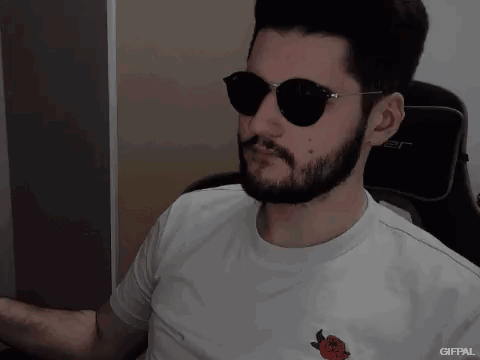A Man With A Beard Wearing Sunglasses And A White Shirt With A Strawberry On It GIF