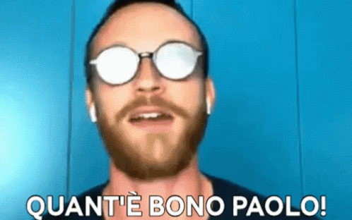 a man with a beard wearing sunglasses and ear buds says quant 'e bono paolo