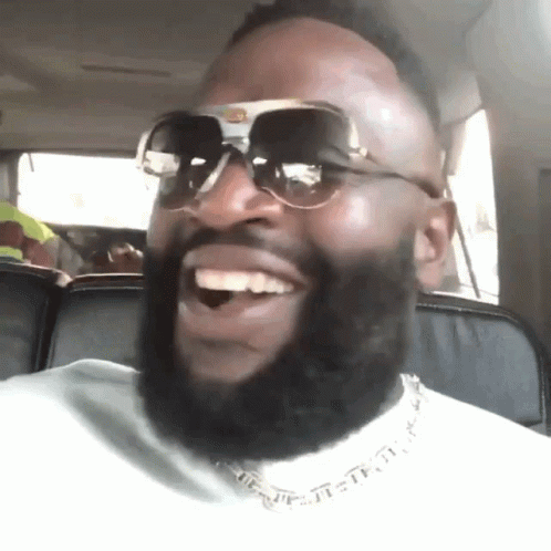 A Man With A Beard Wearing Sunglasses Is Smiling GIF