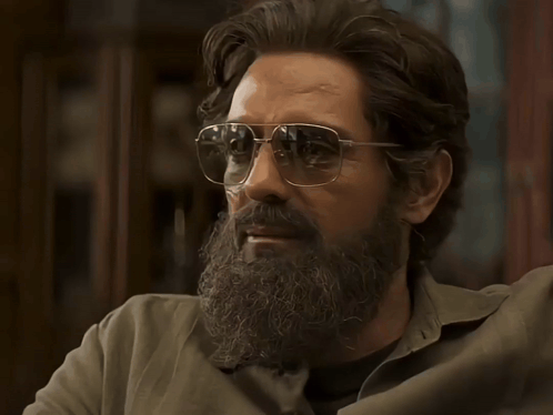 A Man With A Beard Wearing Sunglasses Looks To The Side GIF