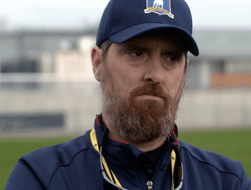 A Man With A Beard Wears A Blue Hat That Says Us Open On It GIF