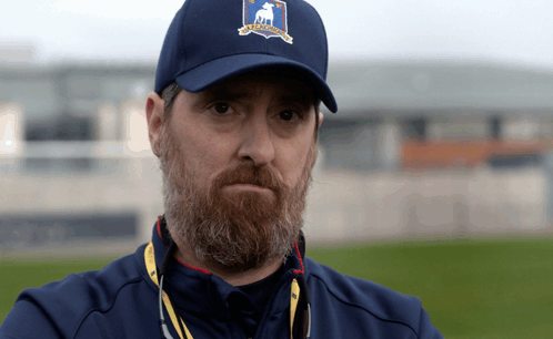 A Man With A Beard Wears A Blue Hat With A Deer On The Front GIF