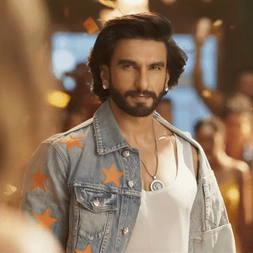 A Man With A Beard Wears A Denim Jacket With Orange Stars On It GIF
