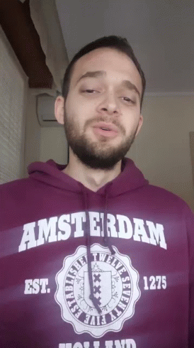 A Man With A Beard Wears A Purple Amsterdam Hoodie GIF