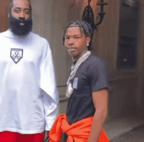 A Man With A Beard Wears A White Shirt With A Shield On The Front GIF