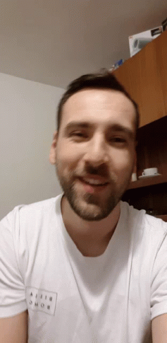A Man With A Beard Wears A White T-Shirt That Says Ajiji Shob On It GIF