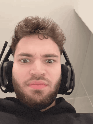 A Man With A Beard Wears Headphones And Makes A Funny Face GIF