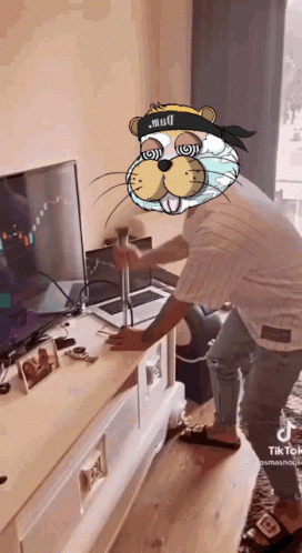 A Man With A Beaver Mask On His Head Is Standing In Front Of A Tv . GIF