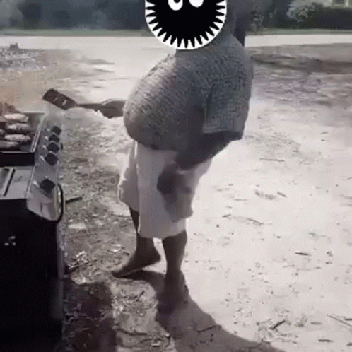 A Man With A Big Belly Is Standing In Front Of A Grill . GIF