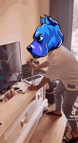 A Man With A Blue Dog Head Stands In Front Of A Laptop GIF