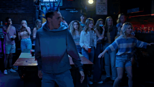 A Man With A Blue Mohawk Stands In Front Of A Sign That Says Connor St. GIF