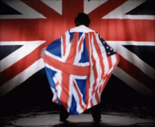 A Man With A British Flag Draped Over His Back GIF