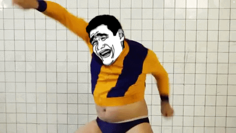 A Man With A Cartoon Face On His Face Is Dancing In Front Of A White Tiled Wall GIF