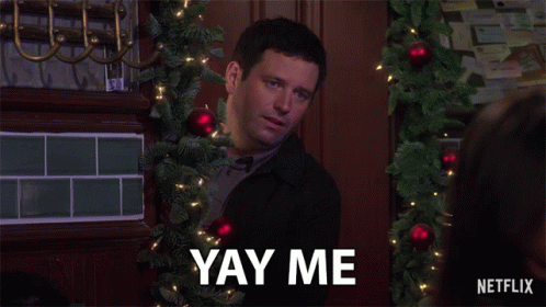 A Man With A Christmas Tree In The Background Says Yay Me GIF