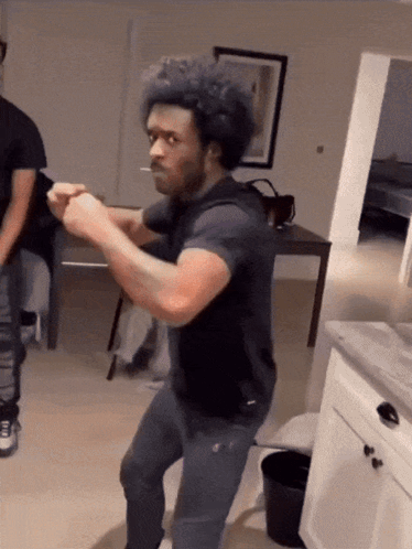 A Man With A Cigarette In His Mouth Is Dancing In A Living Room GIF