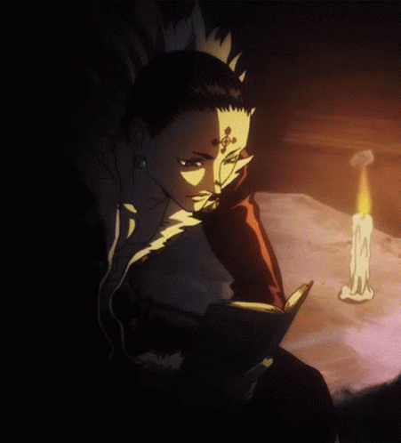 A Man With A Cross On His Forehead Is Reading A Book Next To A Candle GIF