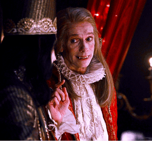 A Man With A Crown On His Head Is Talking To Another Man GIF