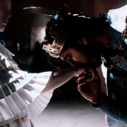 A Man With A Crown On His Head Kissing A Woman 'S Hand GIF