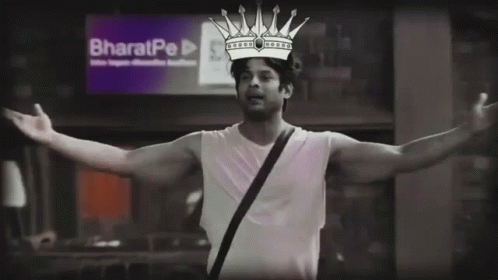 A Man With A Crown On His Head Stands In Front Of A Sign That Says Bharatpe GIF