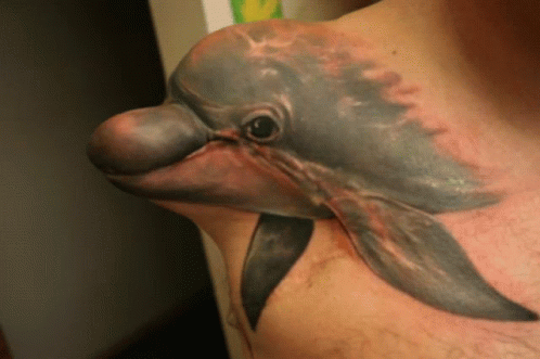 A Man With A Dolphin Tattoo On His Chest GIF