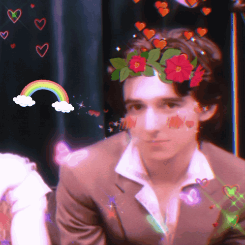 A Man With A Flower Crown On His Head And A Rainbow In The Background GIF