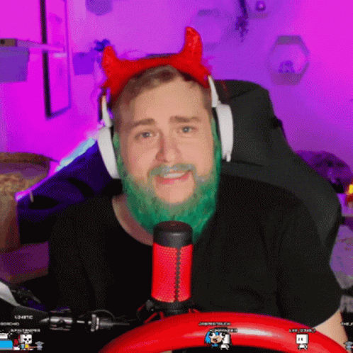 A Man With A Green Beard Is Wearing Headphones And A Red Headband With Horns GIF