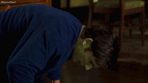 A Man With A Green Mask On His Face Is Looking At The Camera GIF