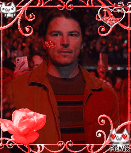 A Man With A Heart On His Cheek Is In A Frame With Hearts And Flowers GIF