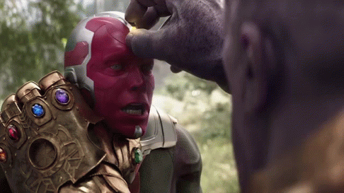 A Man With A Helmet And A Glove With Gems On It Is Being Touched By Another Man GIF
