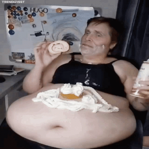 A Man With A Huge Belly Is Eating A Cake With Whipped Cream On It GIF