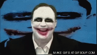 A Man With A Joker Face Painted On His Face Is Smiling In Front Of A Blue Background GIF