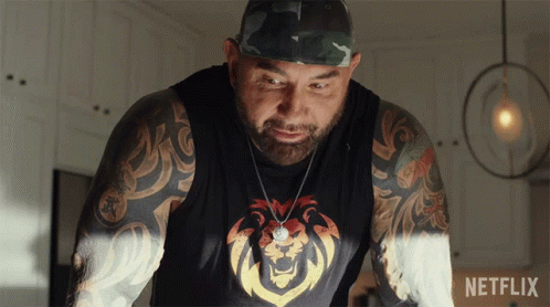 A Man With A Lion On His Shirt Is Standing Next To A Netflix Sign GIF